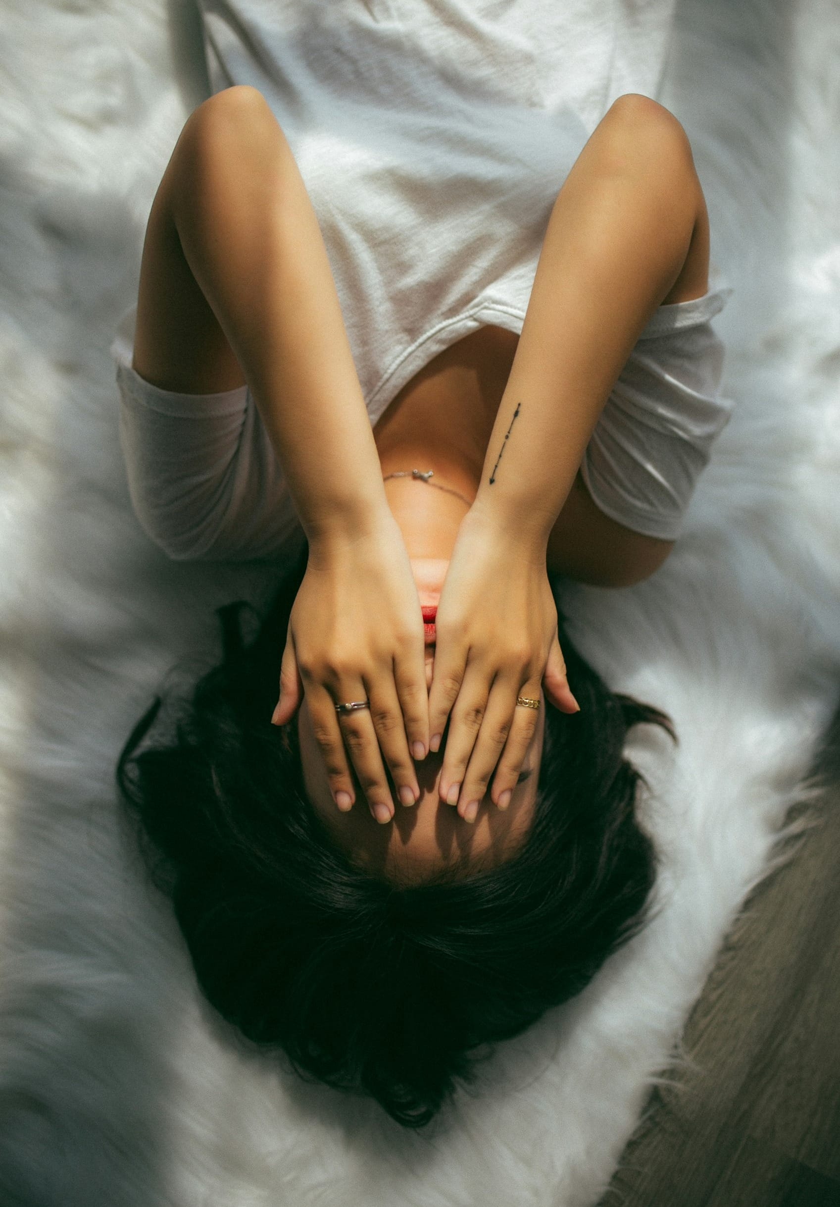 a woman holds her hands over her face